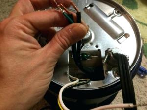 man working on wires of garbage disposal