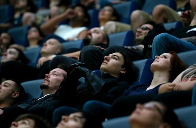 patrons peering up at a movie screen.